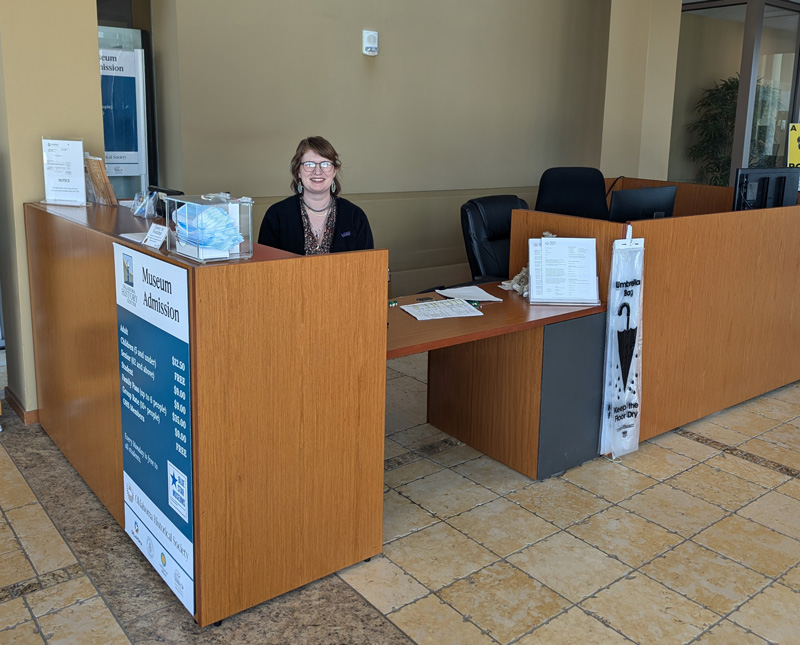 A staff member sitting behind the admissions desk